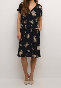 Bloemrijke jurk in marineblauw met korte mouwen, V-hals en een getailleerde taille; inclusief zijzakken en een knie-lange zoom.
