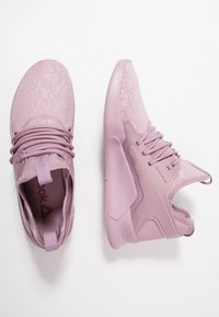 Rosa sportskor med texturerad ovandel, rund tå, vadderad krage och gummisula med snörning.