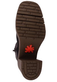 Suela de zapato negra con una superficie de goma texturizada con un patrón de ladrillo. Un logo rojo se muestra en el centro. Diseño robusto y duradero.