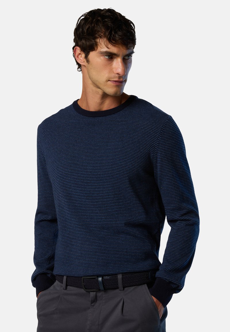 Marineblau gestreifter Pullover mit Rundhalsausschnitt, langen Ärmeln und gerippten Bündchen. Kombiniert mit einem strukturierten schwarzen Gürtel und grauen Hosen.