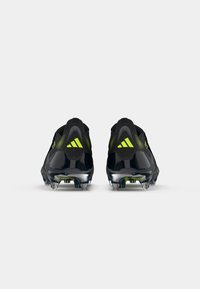 Black and neon yellow cleats with a sleek, aerodynamic design. Features a textured upper and silver studs for traction.