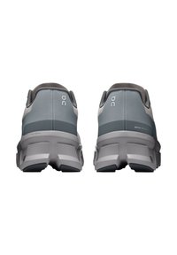 Sneaker grigie e teal con una tomaia testurizzata, tallone imbottito e una suola spessa e segmentata; contrassegnate con "ON" e "Swiss Engineering."