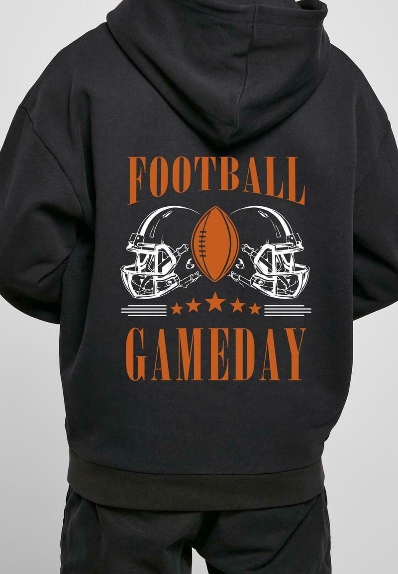 Felpa nera con un grafiche frontale che presenta due caschi da football, un pallone da football e il testo "FOOTBALL GAMEDAY" in arancione e bianco.