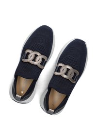Navy knitted sneakers with a slip-on design, featuring a decorative gold chain accent and a white cushioned sole. Interior shows beige lining.