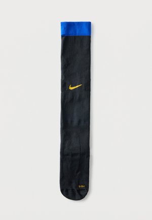 Chaussette noire montante avec bord bleu, logo Nike jaune sur le tibia et texte jaune "MID-R" près des orteils sur fond blanc.