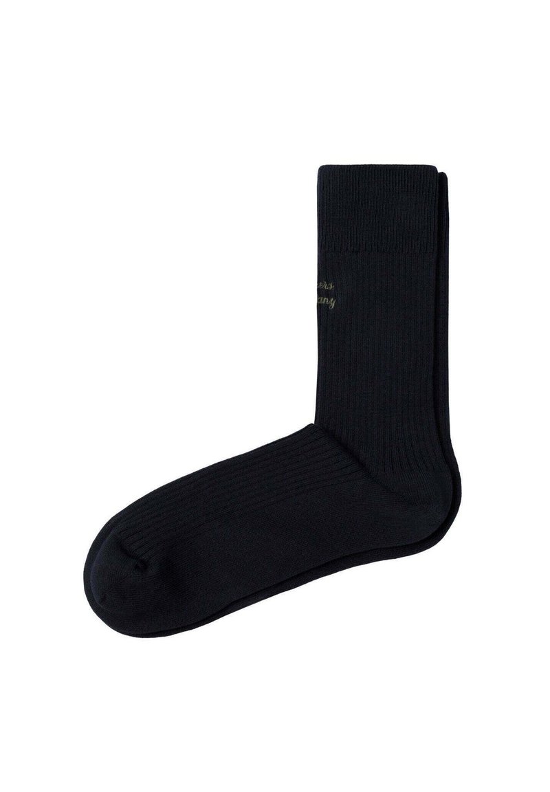 Un par de calcetines negros de canalé, doblados cuidadosamente con un texto sutil bordado cerca del puño superior sobre un fondo blanco.