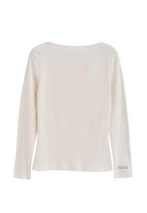 Langærmet top i creme, med rund halsudskæring, ribbet tekstur og diskret broderet logo på nederste højre side.