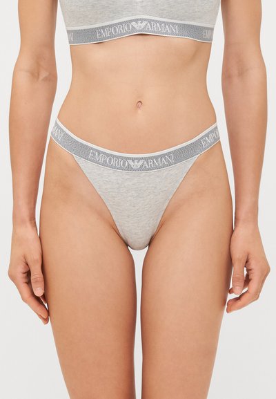 Heled hall puuvillane rinnahoidja ja sobivad stringid elastse rihmaga. Rihma peal on halli ja valgega "Emporio Armani" logo. Pehme, õmblusteta tekstuur.
