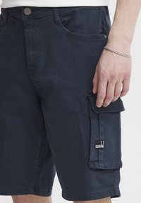Tengerészkék pamut cargo rövidnadrág kényelmes szabással, oldalzsebekkel és "11 PROJECT" logóval ellátott folttal a lábszáron.