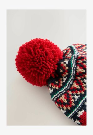 Kootud peapael punase pom-pomiga, geomeetriliste mustritega tumesinises, punases, kreemis ja rohelises. Pehme villane materjal, ümar kuju.