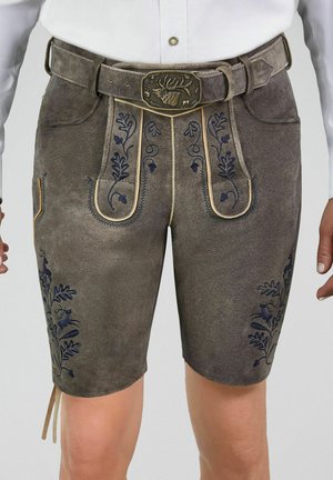 Traditionelle braune Lederhosen aus Leder mit blauer Blumen- und Tierstickerei, getragen mit einem passenden Gürtel mit Hirschschnalle.