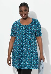Tunic a maniche corte blu con motivo floreale che presenta dettagli in rosso e bianco. Design casual con scollatura rotonda, realizzata in tessuto morbido.