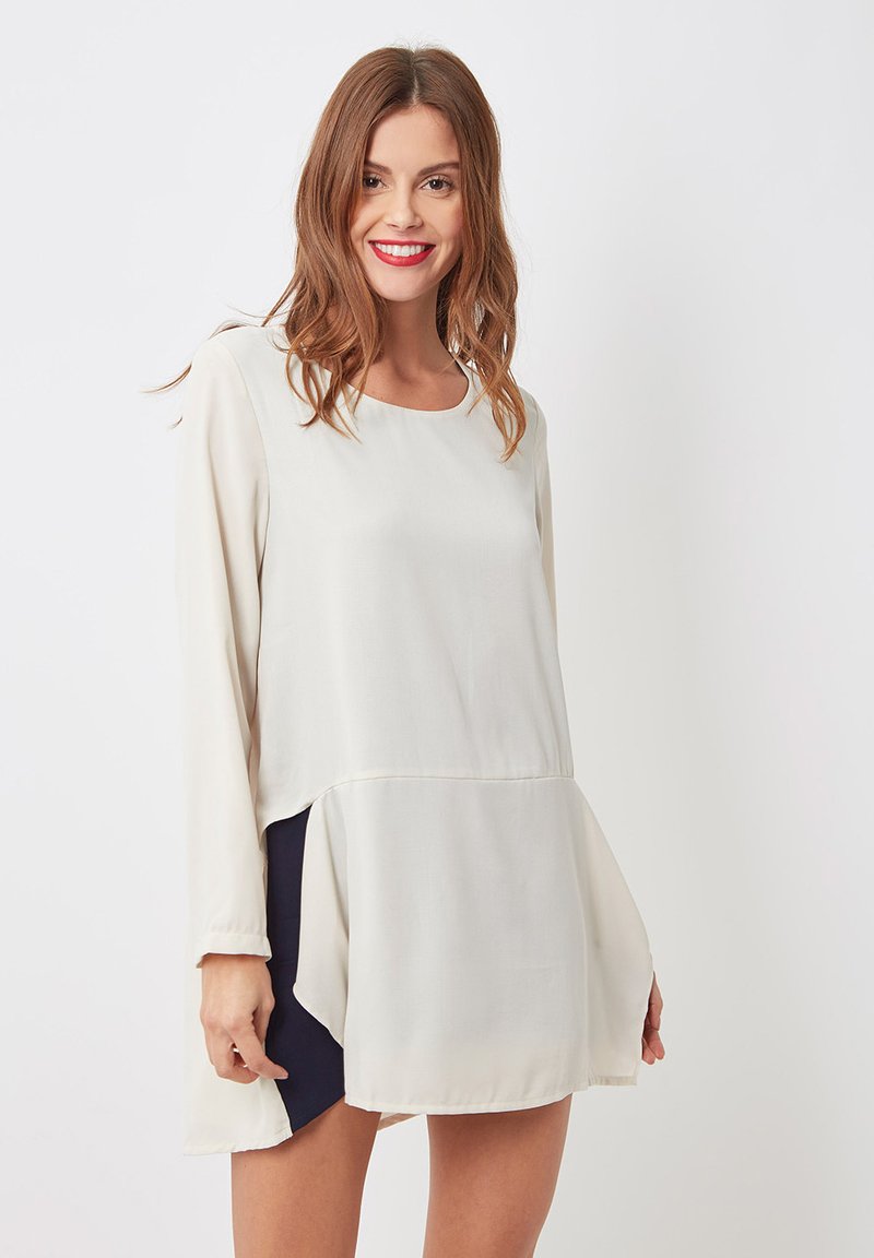 Vestido de manga larga color crema con un dobladillo fluido, que presenta un panel en contraste color marino. Tela suave y ligera con escote redondo.