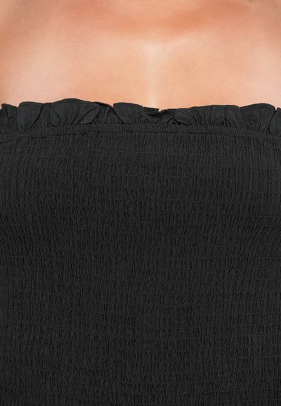 Top negru fără bretele, realizat dintr-un material texturat, crăpat, cu un decolteu cu volane. Material neted și elastic pentru un aspect ajustat.