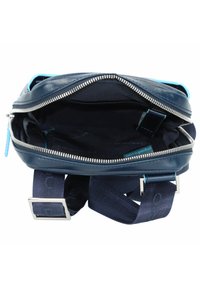 Navyblaue Leder-Crossbody-Tasche mit einem Reißverschlussöffnung, Stofffutter, verstellbarem Tragegurt und Hardware-Details in Silberoptik.
