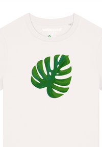 Weißes T-Shirt mit einem großen Druck eines grünen Monstera-Blattes, versehen mit Details in verschiedenen Grüntönen sowie deutlichen Blattadern und Ausschnitten.