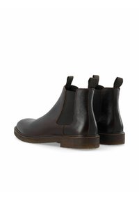 Bottes Chelsea en cuir marron avec panneaux latéraux élastiques et languettes de traction. Texture lisse avec un petit talon bloc et une semelle extérieure en caoutchouc robuste.