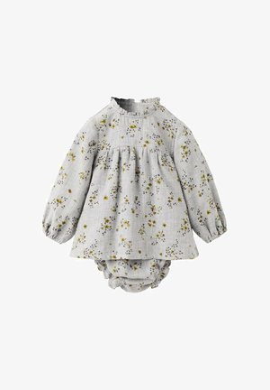 Svetlo sivo cvetlično obleko z dolgimi rokavi, z nabranim pasom in z ruflji na ovratniku; v kombinaciji z ustreznimi hlačkami, ki imajo podoben vzorec.