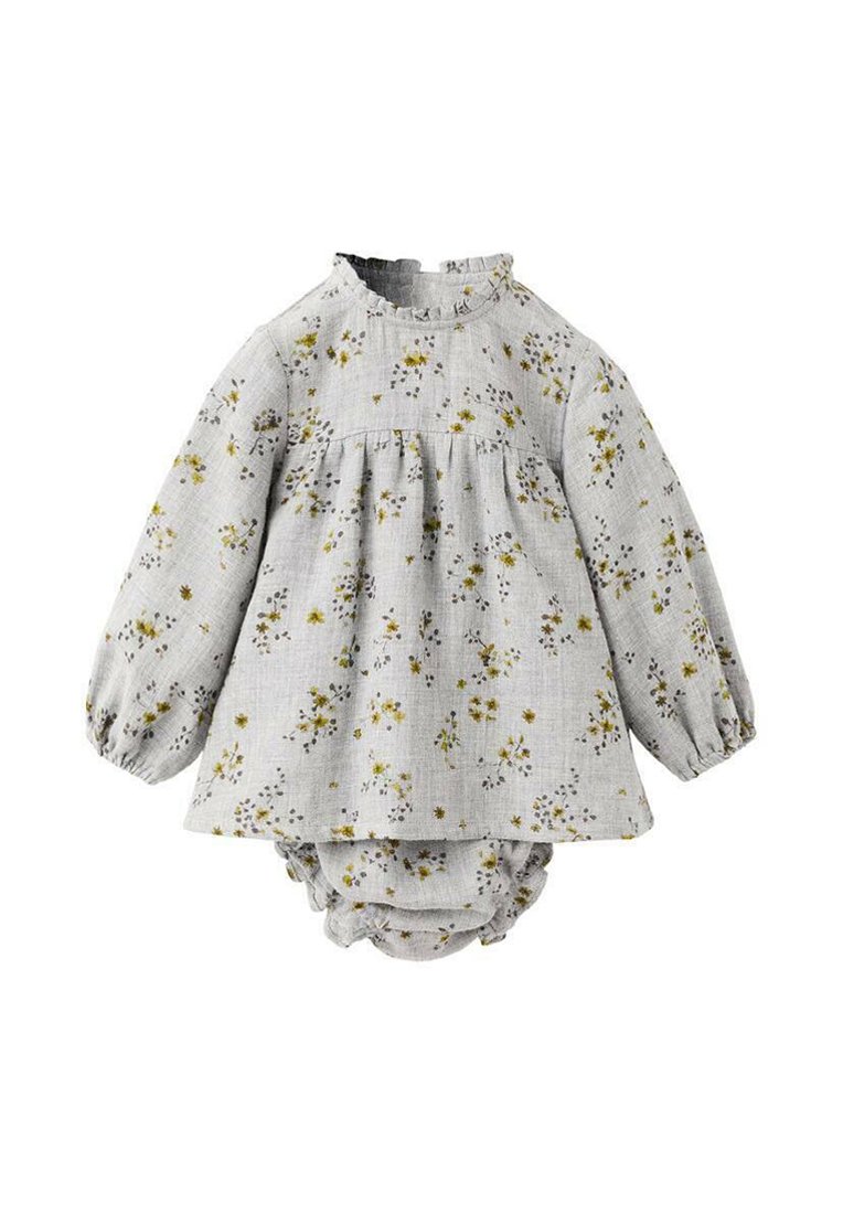 Vaaleanharmaa kukkakuosiset mekko pitkillä hihoilla, kerätty vyötärö ja röyhelökaulus; yhdistetty samanlaiseen kuosiin oleviin haalareihin.