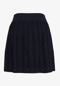 Sukně z tmavě modrého bavlněného materiálu s elastickým pasem, zdobená texturovanou výšivkou s perforací a s rozšířeným střihem. Délka do poloviny stehna.