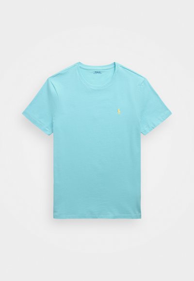 Himmelblå bomull T-skjorte med korte ermer, rund hals og en liten brodert logo i gult på venstre bryst. Glatt tekstur, casual design.