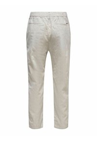 Pantaloni a righe di colore chiaro con vita elastica. Presentano due tasche posteriori e gambe affusolate. Realizzati in un tessuto liscio e strutturato.