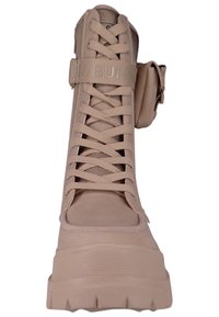 Stivaletto beige alto realizzato in materiale sintetico liscio, con lacci frontalmente, pannelli in rete e una banda con dettaglio del logo. Suola spessa.
