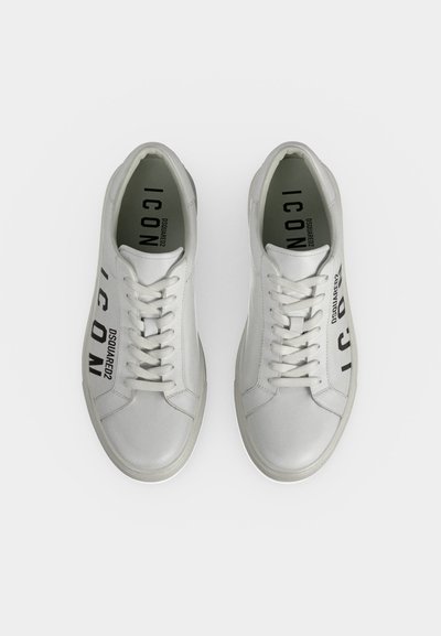Paire de baskets blanches à lacets avec ""ICON DSQUARED2"" imprimé en noir sur les côtés et les semelles intérieures.