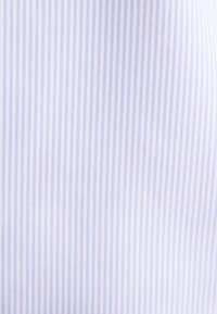 Verticaal patroon van dunne blauwe en witte strepen op stof met een gladde textuur.