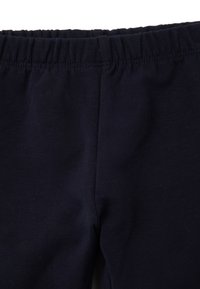 Marineblaue Baumwollleggings mit elastischem Bund, ausgestattet mit einer glatten Textur und einem körpernahen Schnitt ohne Taschen oder Verzierungen.