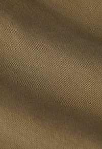 Tissu kaki avec une texture lisse, présentant un motif en côtes diagonales et une couleur uniforme sur la surface.