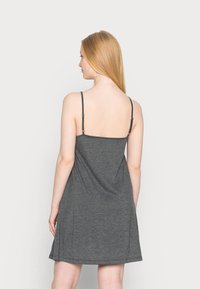 Vestido cinza sem mangas com alças ajustáveis, corte descontraído e textura suave, caindo acima do joelho. Sem padrões ou detalhes visíveis.