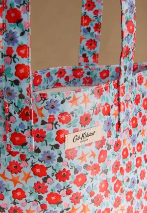 Torebka typu tote w jasnoniebieskim kolorze, ozdobiona czerwonymi, różowymi i fioletowymi kwiatami z zielonymi liśćmi oraz pomarańczowymi gwiazdami. Metka marki po boku.