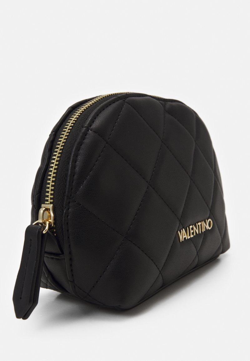 Schwarze, gesteppte Leder-Kosmetiktasche mit einem goldenen Reißverschluss und einem Logodetail. Abgerundete Form mit strukturiertem Finish und Stofffutter.