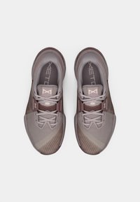 Grå og mauve atletiske sko med en mesh-overdel, gummisåler, rund tå og snørebåndslukning. Har et struktureret gradientdesign.
