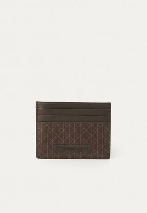 Brown leather card holder with a textured pattern, featuring multiple card slots and a front logo plaque. Compact, rectangular design.
