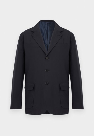 Ανδρικό μαύρο σακάκι μονόπετο με πέτο notch, τρία κουμπιά μπροστά, δύο κάτω τσέπες με καπάκι και μία τσέπη στο στήθος, σε λευκό φόντο.