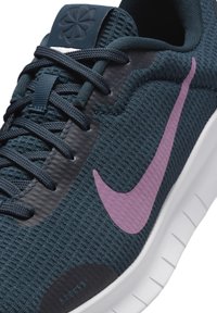 Tumma laivansiniset urheilukengät, joissa on teksturoitu kangas, purppurainen swoosh-logo ja valkoinen pohja. Varustettu verkkomaisella yläosalla ja nauhoitusjärjestelmällä.