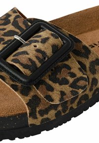 Leopardprint suède sandaal met een zwarte rechthoekige gesp, een tan kleurige voetbed en een getextureerde rubberen zool. Bevat een verstelbare band en uitsparingen.
