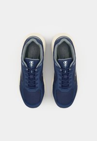 Navy blue athletic shoes with mesh fabric, textured overlays, and cream rubber sole. Features flat laces and logo on tongue.
