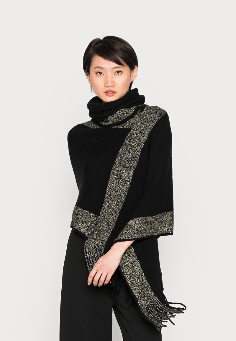 Châle noir avec une rayure texturée or et noire, doté de bords à franges. Matière douce avec un design drapé et un col haut.