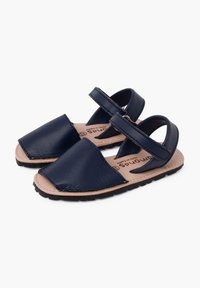 Sandali in pelle blu navy con retro aperto e cinturino regolabile, dotati di suola in gomma piatta e design minimalista.