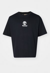 Melnas kokvilnas T-krekls ar brīvu piegriezumu, apaļu kakla izgriezumu, īsām piedurknēm un baltu Timberland logotipu uz krūtīm.
