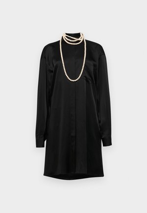 Rochie din satin negru cu mâneci lungi, guler clasic și o buzunar frontal. Include coliere din perle suprapuse ca accente.