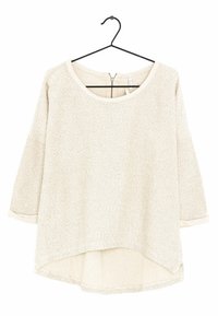 Jasnobeżowa bluzka z długim rękawem o teksturowanym wykończeniu, okrągłym dekolcie i lekko zaokrąglonym dolnym wykończeniem. Posiada zamek z tyłu.