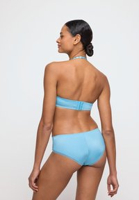 Valkoinen sininen bikinit, jossa on olkaimeton bandeau-yläosa ja vastaavat alaosat. Kangas on sileä, ja siinä on minimalistinen muotoilu ilman näkyviä kuvioita.