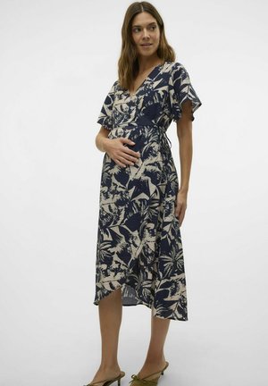 Vestido de maternidad con estampado floral en color marino, con mangas cortas y de volante, diseño cruzado y tejido texturizado. Largo hasta la rodilla con un detalle de lazo lateral.