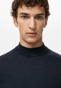 Ciemnoniebieski sweter z półgolfem wykonany z bawełny, charakteryzujący się gładką fakturą i dopasowanym krojem, prezentujący czystą sylwetkę.