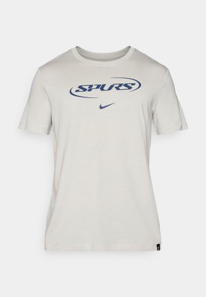 Lichtgrijze katoenen T-shirt met korte mouwen, voorzien van een blauw "SPURS"-logo en het Nike-swoosh. Eenvoudige ronde halslijn en label aan de zoom.