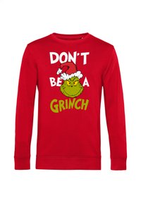 Felpa rossa a maniche lunghe con una grafica del Grinch con un cappello da Babbo Natale, e il testo bianco e verde che recita "NON ESSERE UN Grinch."